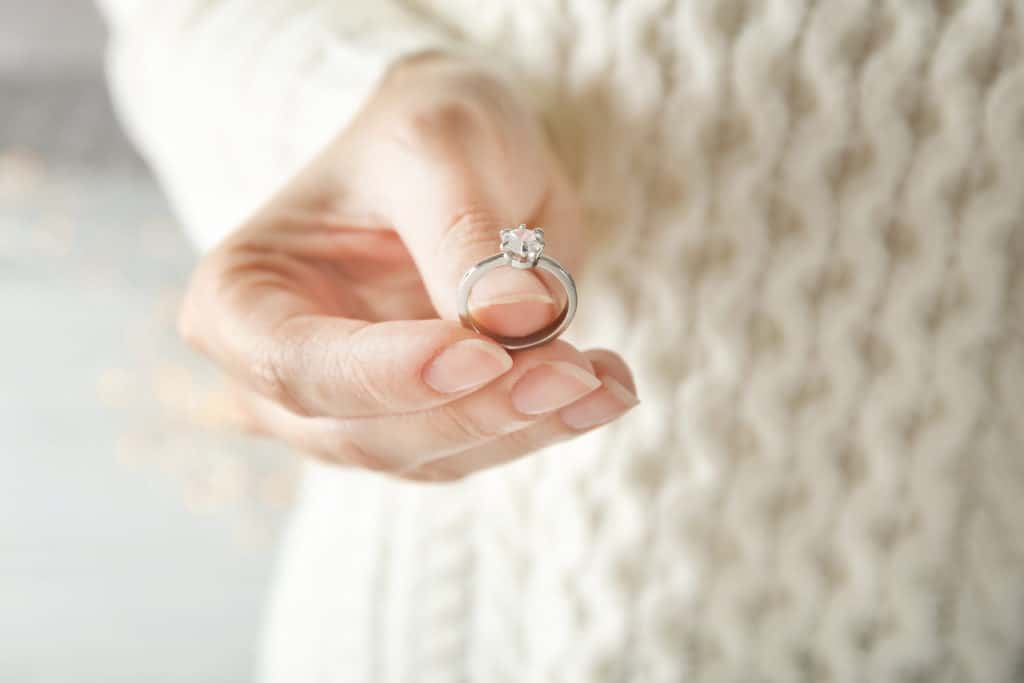 an engaged woman holding her luxury engagement ring, closeup