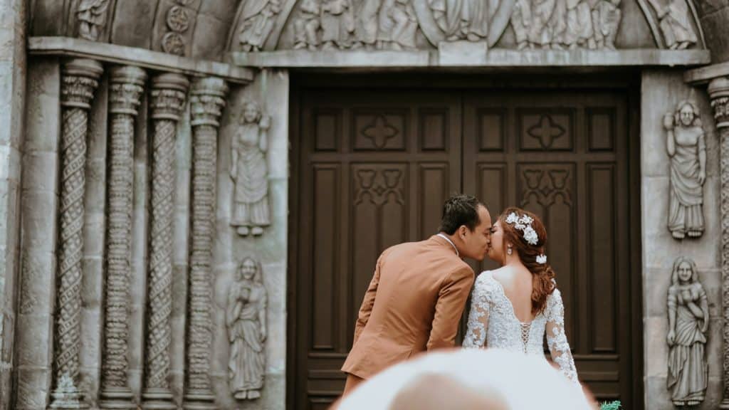 Wedding couple kissing church